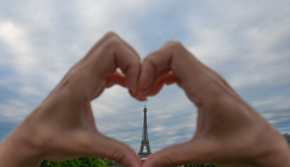Heart in the hands, eiffel tower in paris france.