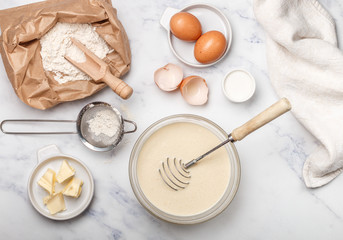 Preparation of dough for home pancakes for Breakfast. Ingredients on the table - wheat flour, eggs,...