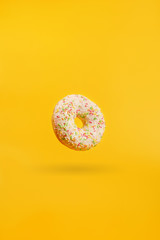 donut on a yellow background with shadow hanging in the air