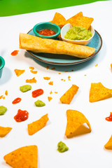 Guacamole sauce and spicy sauce accompanied by nachos.