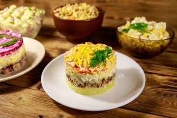 Set of festive mayonnaise salads on wooden table