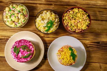 Set of festive mayonnaise salads on wooden table. Top view
