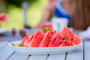 Slices of watermelon on a plate on a wooden background