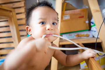 Adorable baby boy nervously expression biting doll and toy