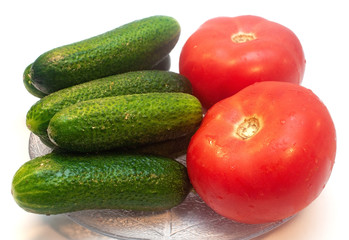 Cucumbers with tomatoes in a plate on a white background