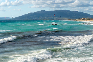 Awesome view - colorful kites over the Ocean, wind turbines on the hill and sandy Los Lances beach. Tarifa is a paradise for nature and water sports lovers. Tarifa, Cadiz, Andalusia, Spain, Europa © RasaBasa