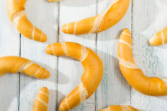 crescent rolls on white wooden table, directly above