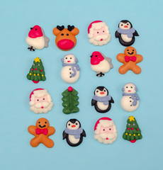 Sugar glaze figurines for Christmas decoration. Christmas food decorations.  Christmas symbols. Christmas cookies on blue background from above. Desert.