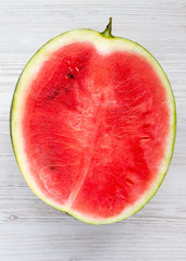 Fototapeta na wymiar Fresh cut watermelon on a white wooden surface, top view. Close-up.