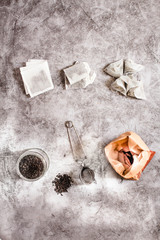 Metal thermos and tea infuser. Black tea in a jar and a paper bag. Zero waste plastic free kitchen on gray  background. concept sustainable lifestyle or Recycling and ecology