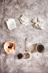 Metal thermos and tea infuser. Black tea in a jar and a paper bag. Zero waste plastic free kitchen on gray  background. concept sustainable lifestyle or Recycling and ecology
