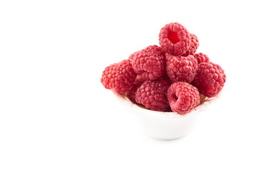 Red raspberry berries on a saucer isolated on a white background.