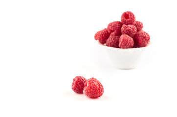 Red raspberry berries on a saucer isolated on a white background.