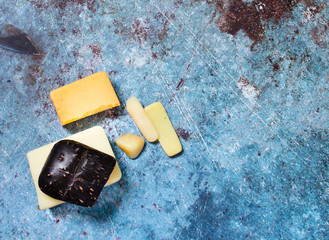 Different Soap bar on a ceramic soap dish on a blue background.