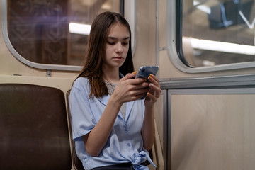 Fototapeta na wymiar Teen girl rides the subway and used smartphone 