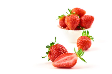 Strawberry berries and strawberry slice on a saucer isolated on a white background.