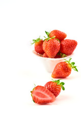 Strawberry berries and strawberry slice on a saucer isolated on a white background.
