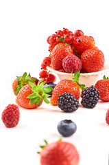 Composition of strawberries, blackberries, blueberries, raspberries and red currants on a white background.