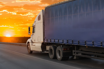 Fototapeta na wymiar Big truck semi trailer moves on the highway