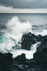Fototapeta na wymiar Azores, Big waves crashing over black volcanic rock on the Atlantic Ocean in the coast of Sao Miguel island in the Azores, Portugal