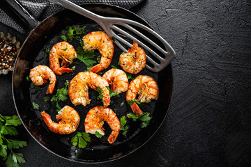 Grilled shrimps on pan on dark background
