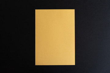 Blank gold paper sheet on black background. Layout for business, posters and banners.
