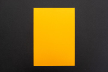 Blank orange paper sheet on black background. Layout for business, posters and banners.