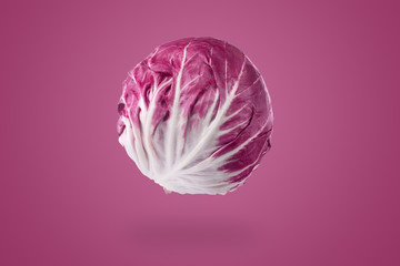 whole red radicchio over purple background, healthy vegetarian food