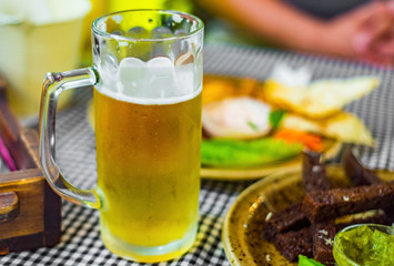glass of beer and snack on table in bar