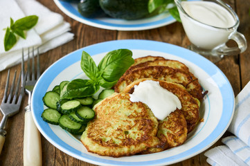 Zucchini fritters with sour cream, cucumbers and basil