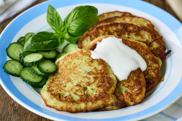 Zucchini fritters with sour cream, cucumbers and basil