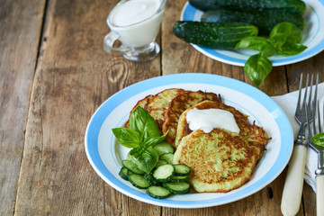 Zucchini fritters with sour cream, cucumbers and basil