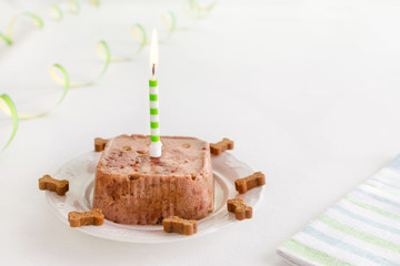 happy birthday cake for dog from wet food and treats with candle and copy space