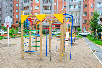 Fototapeta na wymiar Children's playground after rain in the usual courtyard of an apartment building. provincial town. summer. Russia
