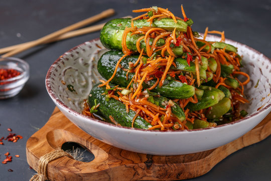 Traditional Korean cucumber kimchi snack: cucumbers stuffed with carrots, green onions, garlic and sesame, fermented vegetables, horizontal photo