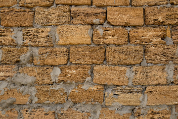 Fototapeta premium Brick wall of yellow shell rock. Closeup of shellstone texture. Background wall with shell rock. Old wall. Texture limestone