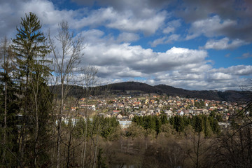 Fototapeta na wymiar view from the hill from the forest to the small town houses in spring