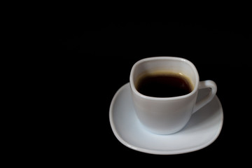 Coffee in a white cup on a dark colored background