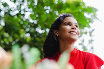Outdoor portrait of young beautiful girl 19 to 25 years old posing in street. Brunette. riding a retro styled bicycle. Wearing red blouse With a penetrating camera look. 