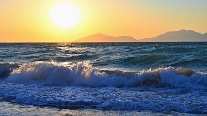 Fototapeta na wymiar Beautiful sunset with sea and waves. Natural colorful background. Concept for summer and sea vacation. Greece - island of Kos.