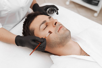 Cleaning the face of a man in a beauty salon.