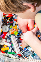 Boy playing with plastic construction toys on the floor.