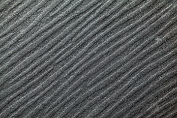 Cement surface with a pattern of gray angled lines.