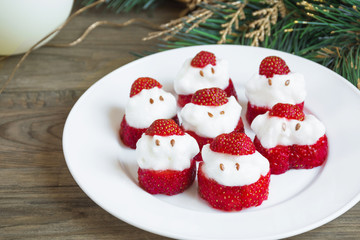 New Year's  party ideas for kids. Christmas snack from strawberry and whipped cream. Strawberry Santa Claus recipe