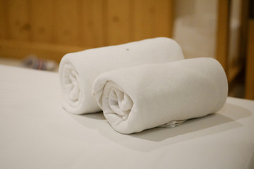 Obraz na płótnie Canvas Roll of white towel on bed