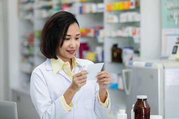 young asian women pharmacist check drugs and packages in pharmacy store