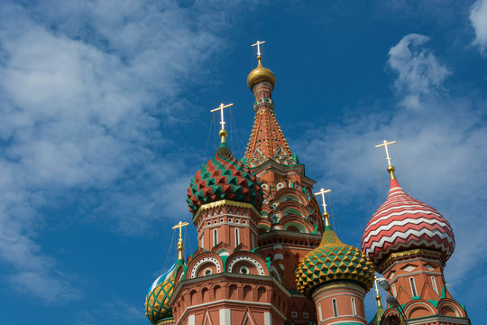 Multicolor towers of St. Basil's Cathedral against the cloudy sky.