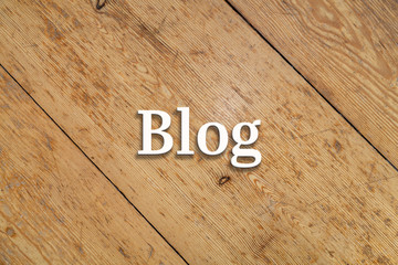 'Blog' white text on a wooden background. 
