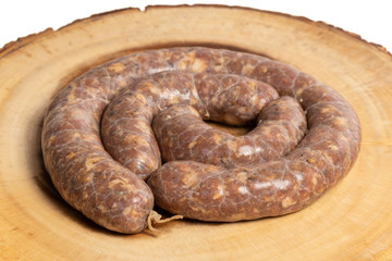 Raw homemade stuffed pork sausages isolated on a woodboard.