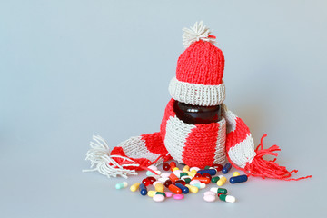a bottle of syrup dressed in a scarf and cap in the season of colds